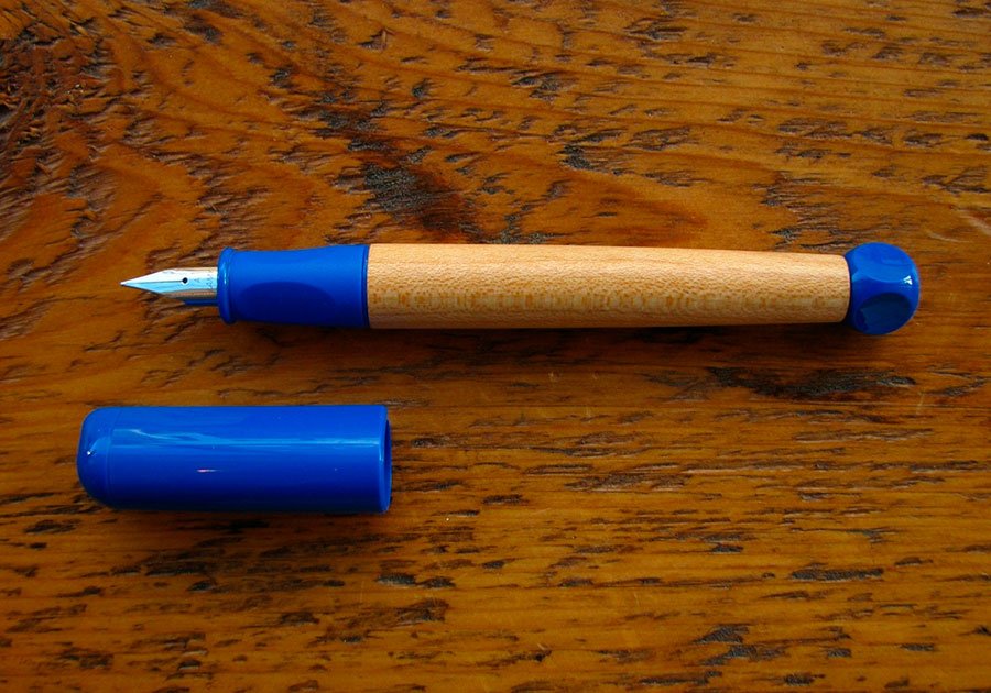 pluma estilografica ABC de lamy. El cuerpo es de madera y la cogida de plastico blando de color azul.