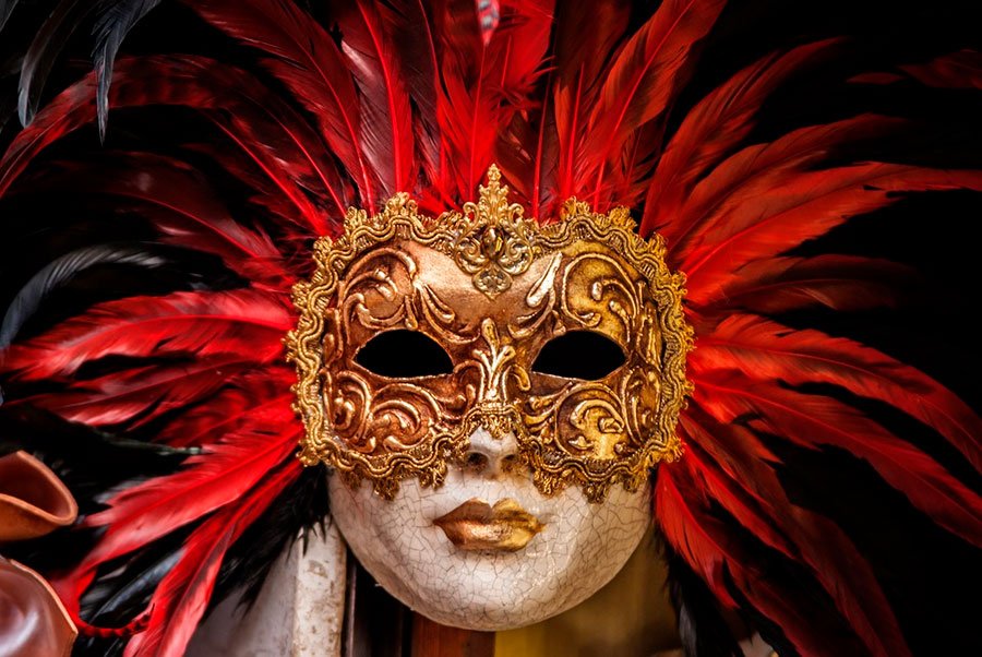 mascaras de yeso con plumas de color rojo y negro.