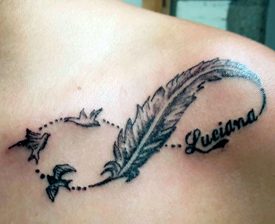 pluma tatuada con aves volando alrededor de su nombre. diseños de tatuajes de plumas,tatuajes de plumas y golondrinas,plumas de pavo real tatuaje,tatuajes en la espalda de plumas,tatuajes de plumas de indios,significado de tatuajes de plumas de aguila,significado del tatuaje de plumas,tatuajes de plumas en la pierna.